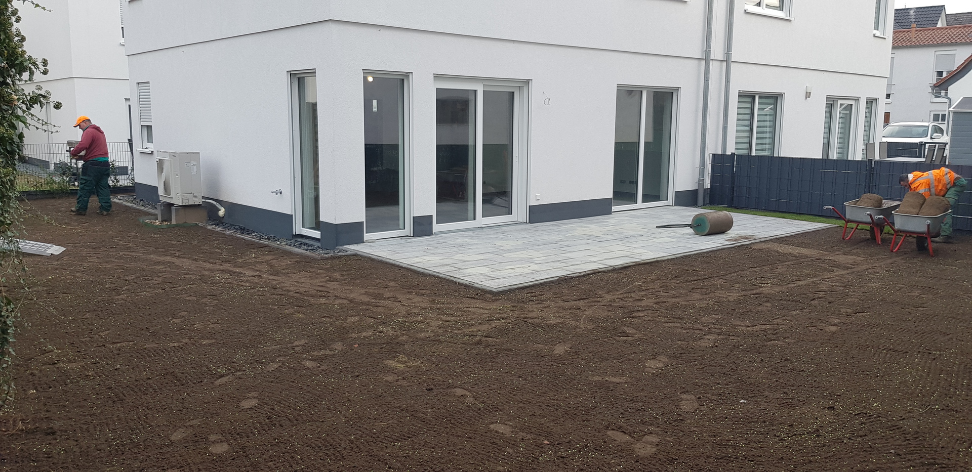 Verlegung von Rollrasen rund um eine neu gebaute Terrasse